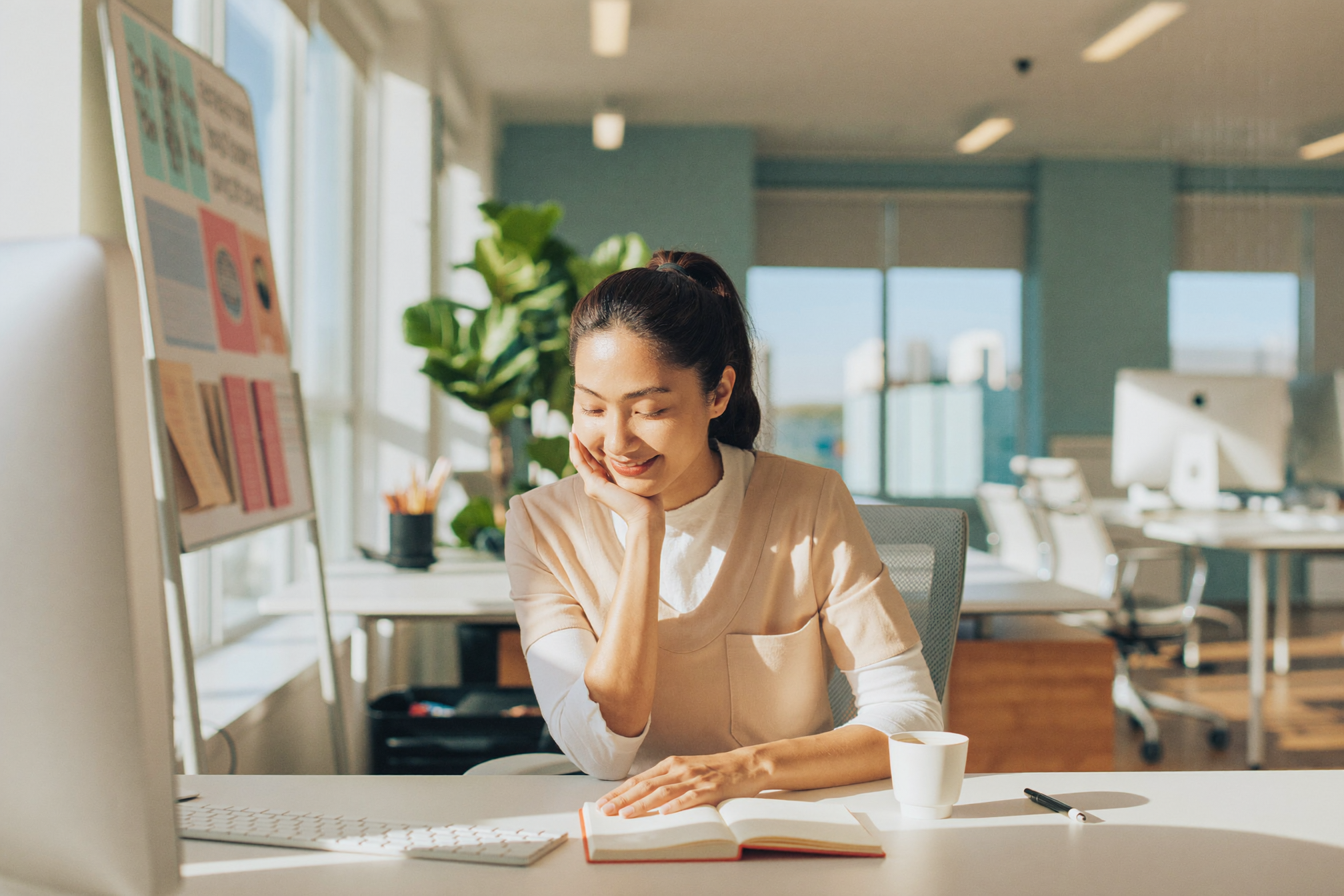A staffing coordinator reviewing a weekly staff schedule in a bright facility office